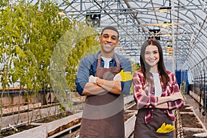 Positive multiethnic farmers in aprons crossing