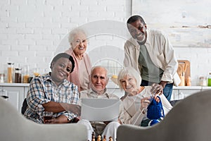 Positive multiethnic pensioners with yarn, tea