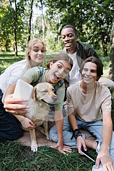 Positive multiethnic teenagers with retriever taking