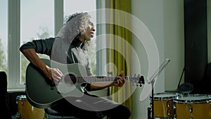 Positive Musician Play Guitar and Sing .