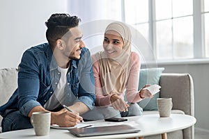 Positive muslim family counting their spendings, feeling wealthy