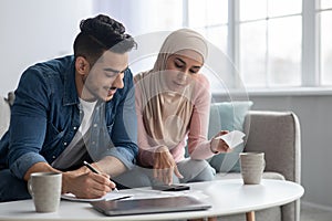 Positive muslim family counting their spendings, feeling wealthy