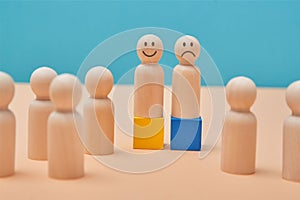 Positive and negative thinking. Emotions of people. Wooden people miniatures with smile, sad and unemotional emoji