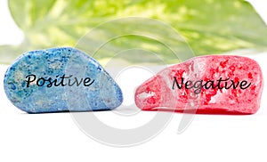 Positive negative written on colored stones photo