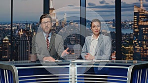 Positive news readers talking live tv newscast in night channel studio closeup