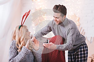 Positive nice man showing his girlfriend an engagement ring