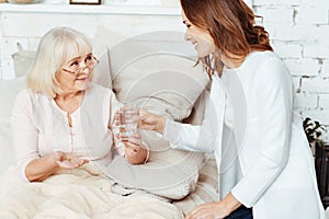 Positive nurse visiting sick woman at home