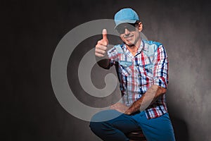 Positive old casual man in trucker hat making ok sign