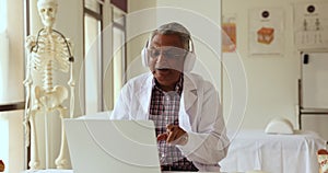 Positive old Indian practitioner giving online consultation