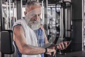 Positive old male is spending time in athletic center