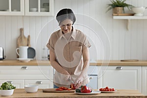 Positive older mature chef woman cooking salad
