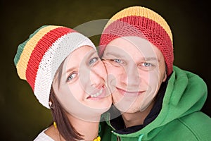 Positive pair in reggae hats smile together