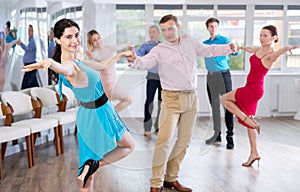 Positive pairs practicing vigorous jive movements in dance class