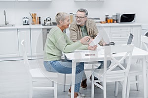 Positive pensioners holding documents near devices