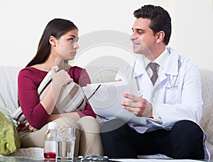 Positive physician consulting sick woman in domestic interior