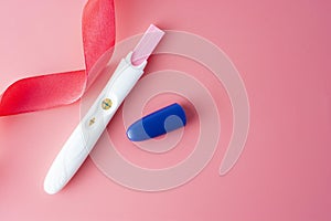 Positive platic pregnancy test isolated on pink background, copy space