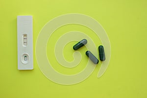 positive pregnancy test and pills on a yellow background. Vitamins. Motherhood, children, pregnancy, the concept of