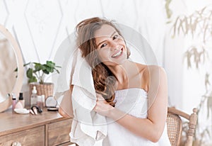 Positive pretty girl drying her hair with towel after shower