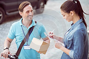 Positive professional courier delivering the parcel