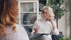 Positive psychoanalyst smiling laughing during conversation with female patient