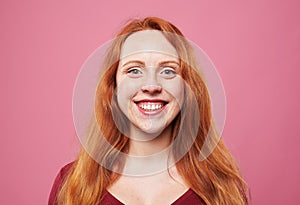 Positive redhead young girl smiling at the camera