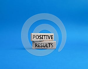Positive results symbol. Concept words Positive results on wooden blocks. Beautiful blue background. Business and Positive