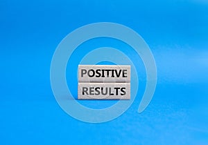 Positive results symbol. Concept words Positive results on wooden blocks. Beautiful blue background. Business and Positive