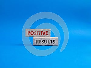 Positive results symbol. Concept words Positive results on wooden blocks. Beautiful blue background. Business and Positive