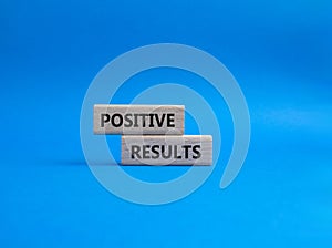 Positive results symbol. Concept words Positive results on wooden blocks. Beautiful blue background. Business and Positive