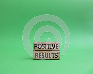 Positive results symbol. Concept words Positive results on wooden blocks. Beautiful green background. Business and Positive