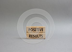 Positive results symbol. Concept words Positive results on wooden blocks. Beautiful grey background. Business and Positive