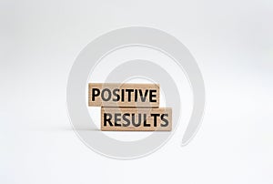 Positive results symbol. Concept words Positive results on wooden blocks. Beautiful white background. Business and Positive