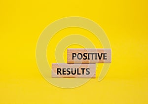 Positive results symbol. Concept words Positive results on wooden blocks. Beautiful yellow background. Business and Positive