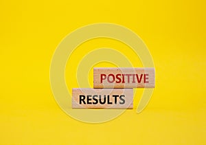 Positive results symbol. Concept words Positive results on wooden blocks. Beautiful yellow background. Business and Positive