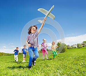 Positive running kids and boy holding airplane toy