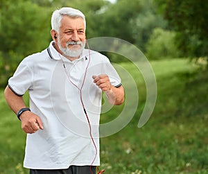 Positive running old man in green city park.