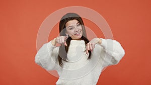 Positive satisfied woman pointing fingers down at advertising area showing thumbs up