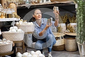 Woman selecting decorative candles in christmastime