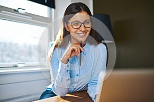 Positive self-employed woman working near window