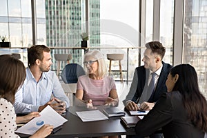 Positive senior business leader woman meeting with younger colleagues