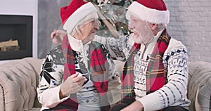 Positive senior Caucasian couple throwing out gift boxes and hugging. Happy old husband and wife spending New Year`s eve