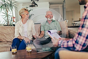 Positive senior couple consulting with insurance agent