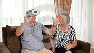 Positive senior couple trying up virtual reality glasses