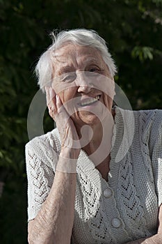 Positive senior woman watering decorative plants on balcony