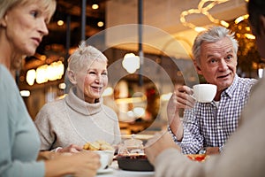 Positive seniors drinking tea together