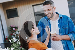 Positive smiling couple standing near their house