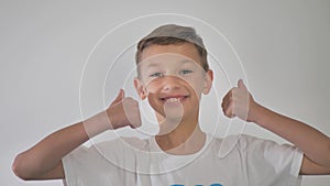 Positive smiling man with thumb up on a white isolated background. Studio video.