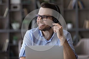 Young guy remote consultant in headset feel glad helping customers photo