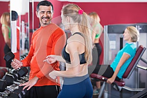 Positive smiling people weightlifting training in health club