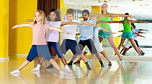 Preteen dancers practicing dance routine with female choreograph